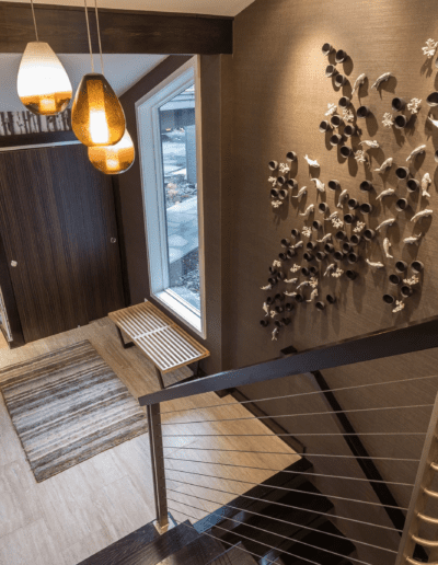 A hallway in a home with a wooden railing and wall art.