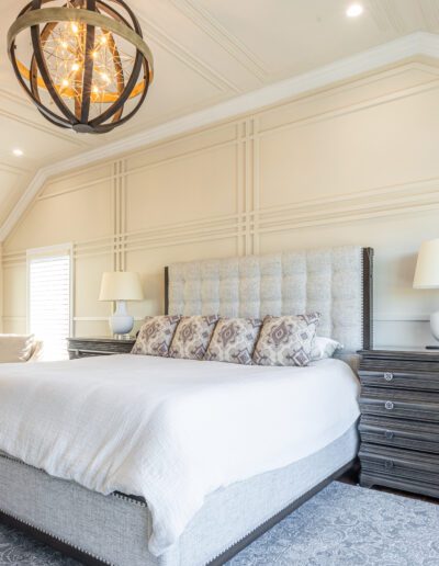 A bedroom with a large bed and a chandelier.